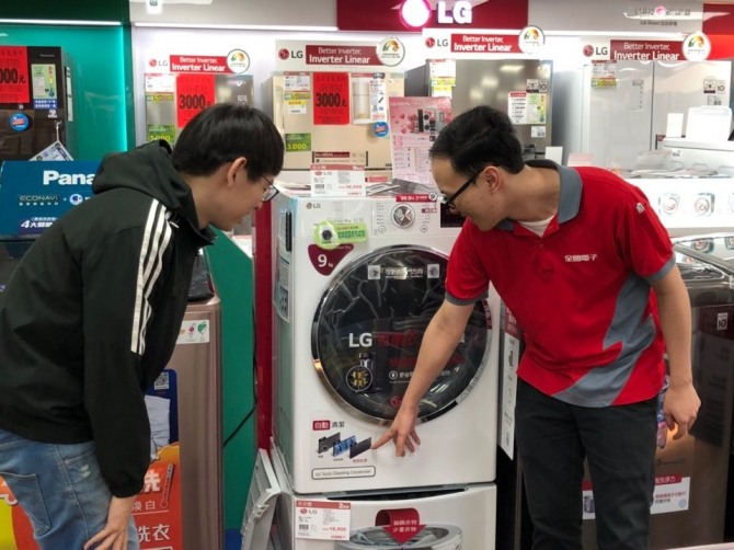 대만의 한 가전매장에서 매장직원이 고객에게 LG 건조기의 차별화된 콘덴서 자동세척시스템을 소개하고 있다. (사진=LG전자 제공)