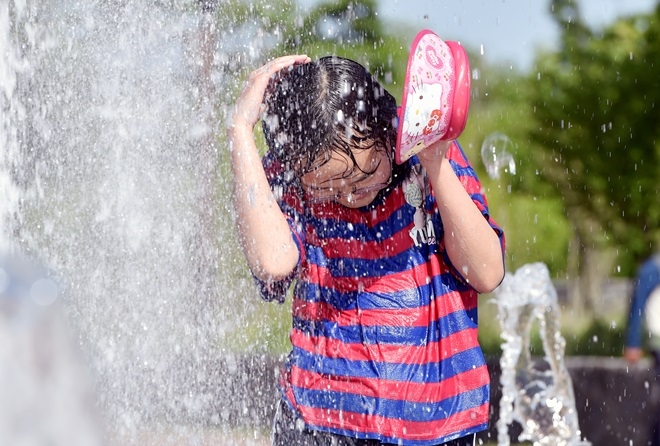 25일 낮 기온이 32도를 넘는 무더위가 계속되고 있는 가운데 대구 동구 율하체육공원 광장 분수대를 찾은 한 어린이가 물놀이하며 더위를 식히고 있다.  사진=뉴시스