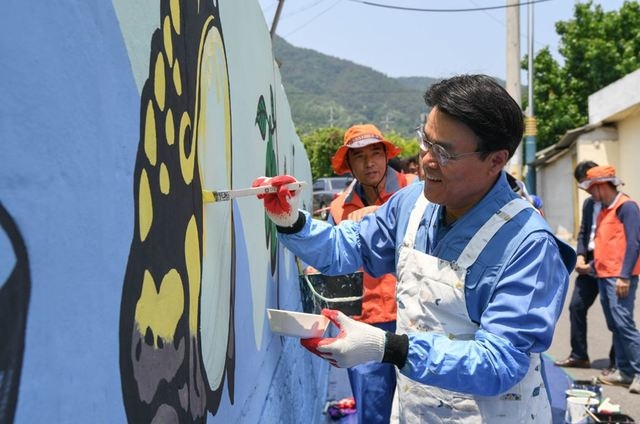 최정우 포스코그룹 회장이 글로벌 볼런티어 위크 첫날인 24일 광양 섬거 마을에서 임직원들과 벽화그리기 봉사활동을 하고 있다.
