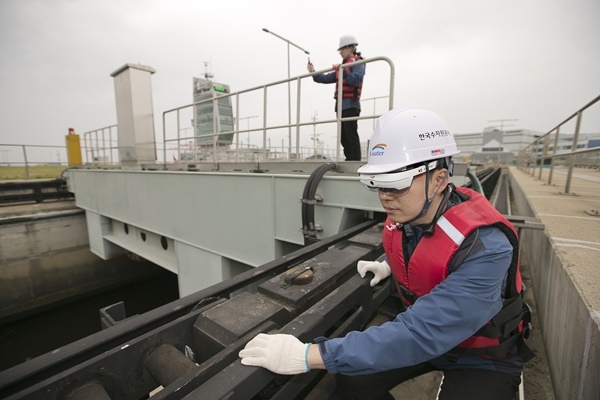 수자원공사 시설물 관리 직원이 KT 5G 스마트글래스와 360도 넥밴드를 착용하고 아라뱃길 시설물을 점검하고 있다.