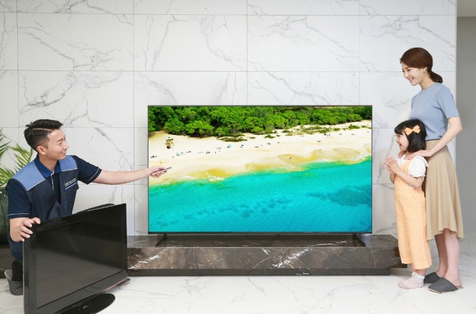 삼성전자 TV 설치기사가 '대국민 TV 보상 페스티벌'을 통해 TV를 구매한 소비자 가정에서 구형 TV를 회수하고 2019년형 QLED TV를 설치한 후 사용법을 설명하고 있다. (사진=삼성전자 제공)