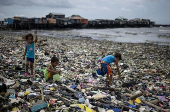 어린아이들이 바닷가 쓰레기더미에서 재활용품을 줍고 있다. 사진=아시아뉴스