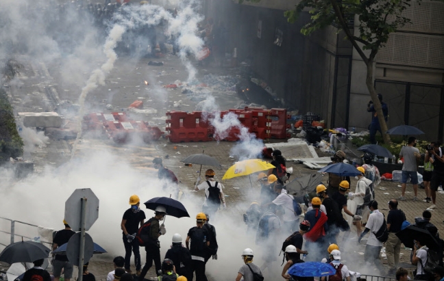 12일 홍콩 입법회(의회) 건물 주변에서 경찰이 '범죄인 인도 법안'에 반대하는 시위대를 향해 최루가스를 발포하고 있다.