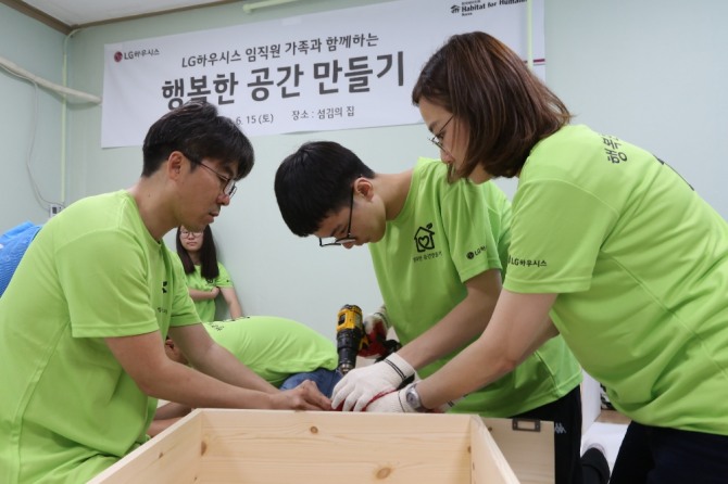LG하우시스 임직원과 자녀 30여명이 15일 서울 신림동의 지역아동센터 '섬김의 집'에서 아이들이 사용할 DIY 사물함을 만들고 있다. 사진=LG하우시스 