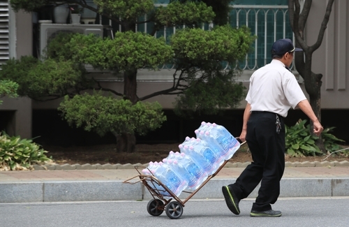 지난 21일 오후 한 아파트 단지에서 경비원이 아리수를 운반하고 있다./연합뉴스 