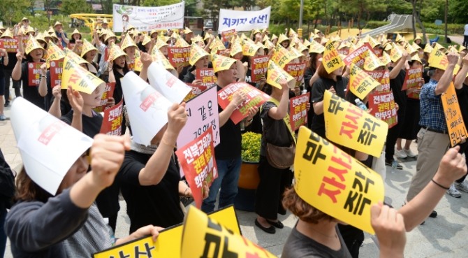 전북 상산고등학교 동문과 학부모들이 지난 20일 전북도교육청 입구에서 상산고 자사고 재지정 탈락에 항의하는 문구 등이 적힌 손피켓을 들고 구호를 외치고 있다. 사진=뉴시스