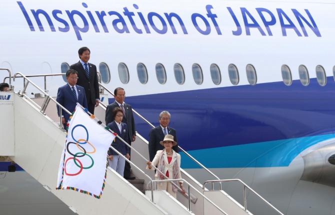 2020 하계올림픽 개최지인 일본 도쿄의 고이케 유리코 도지사가 지난 2016년 8월 도쿄 하네다 국제공항에서 올림픽 깃발을 들고 비행기 트랩을 내려오고 있다. 사진=뉴시스