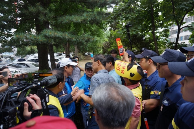 옥상 철탑 시위를 위해 단지 내부로 진입하려는 재건축 조합 측과 이를 제지하려는 경찰들이 몸싸움을 벌이고 있다. 사진=김하수 기자