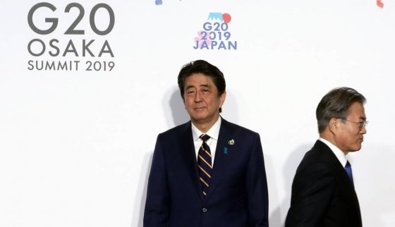 문재인 대통령이 지난달 28일 일본 오사카에서 열린 G20 정상회의 공식환영식에서 의장국인 일본 아베 신조 총리와 악수한 뒤 행사장으로 향하고 있다. 