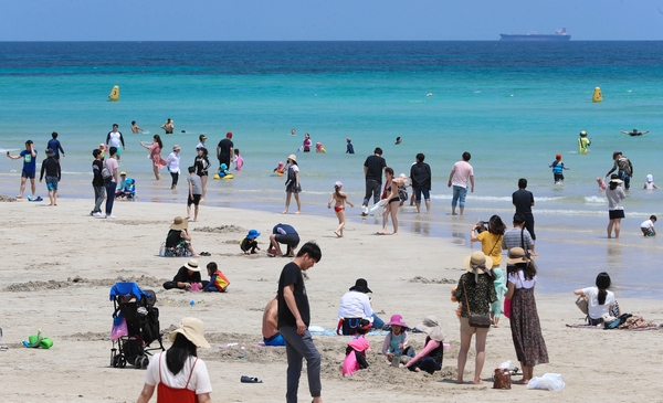 지난해 6월 조기 개장한 제주도 함덕해수욕장에서 피서객들이 물놀이를 즐기고 있다. 이통3사의 할인혜택을 이용하면 국내외 여행과 피서를 위한 나들이를 알뜰하게 즐길 수 있다. (사진=뉴시스)