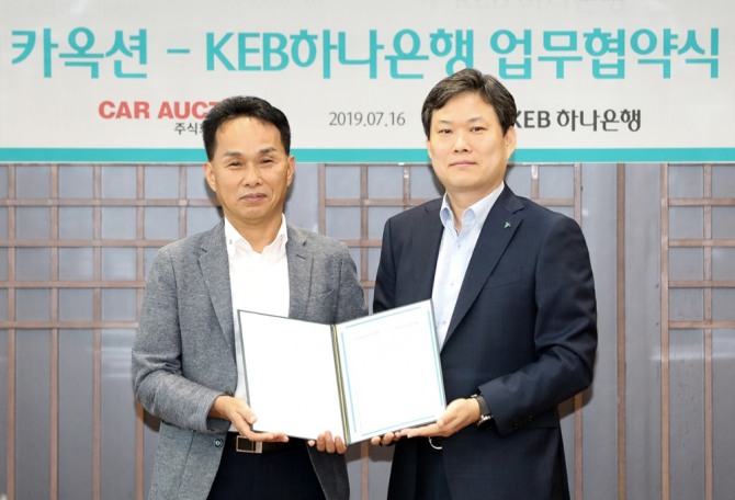 KEB하나은행은 16일 서울 을지로 본점에서 ㈜카옥션과 '자동차 플랫폼 비즈니스' 활성화를 위한 전략적 업무 협약을 체결했다. 이장성 하나은행 영업지원본부장(오른쪽)이 장영수 카옥션 대표와 기념촬영을 하고 있다. 사진=하나은행