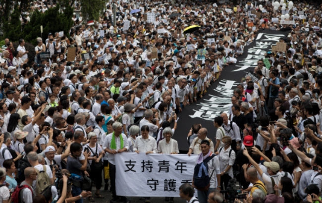 17일 홍콩 도심 차터가든에서 수천 명의 노인이 '홍콩을 수호하는 청년을 지지한다'는 내용의 플래카드를 앞세우고 거리를 행진하고 있다.