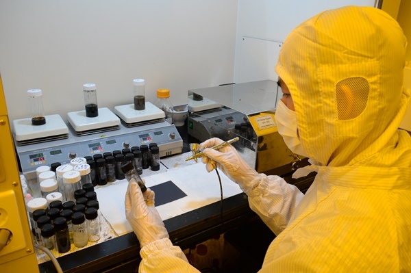 ETRI 탐반누엔 UST 박사과정 학생이 전도성 나노 소재를 유연 플라스틱 기판 위에 스프레이 코팅하는 모습(사진=ETRI)