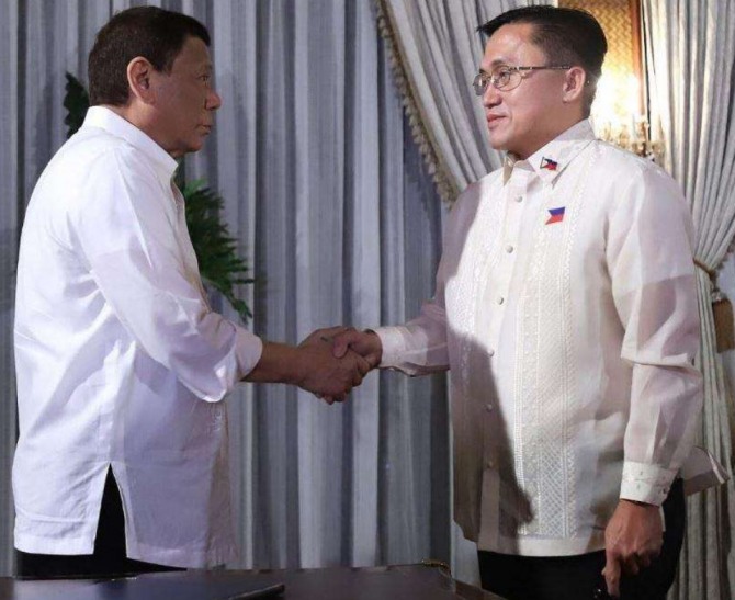 로드리고 두테르테 필리핀 대통령(왼쪽)과  봉 고 대통령 보좌관이 지난 23일 만나 악수를 하고 있다.  사진=GMA 뉴스