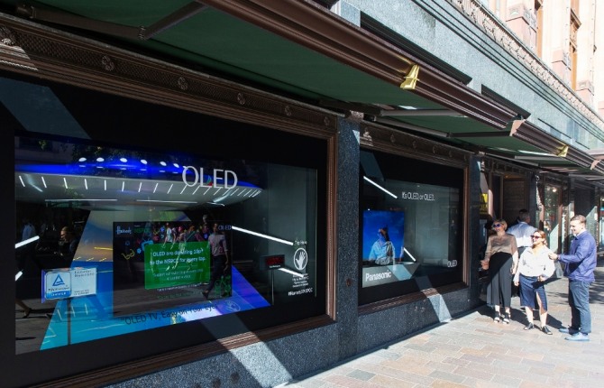LG디스플레이가 영국 해롯백화점 1층 쇼윈도에 전시한 글로벌업체들의 OLED TV를 방문객들이 관람하고 있다. 사진=LG디스플레이 제공