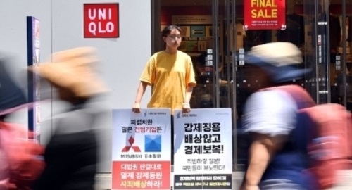 일본기업들은 일본의 한국 화이트국 제외에  그 영향은 제한적이라고 밝히면서도 한국내 불매운동에 대해서는 경계감을 드러냈다. 사진은 한 여성이 유니클로 매장 앞에서 불매운동을 벌이고 있는 모습.