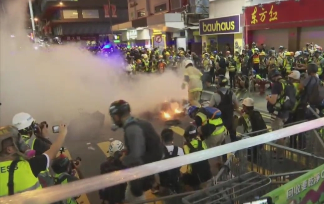 홍콩 번화가에서 시위대가 경찰의 최루탄에 맞서 쓰레기를 불태우면서 이에 저항하고 있다.