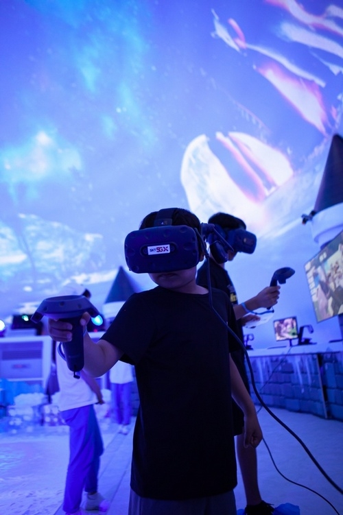 SK텔레콤의 부산 해운대 ‘5GX 이글루’를 찾은 방문객들이 VR눈싸움을 체험하고 있다.(사진=SKT)