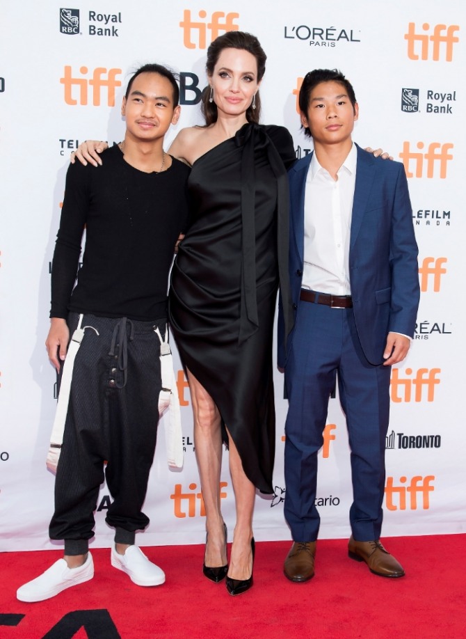 할리우드 배우 앤젤리나 졸리(가운데)가  지난해 11월 5일 캐나다 토론토에서 열린 토론토 국제 영화제에서 큰 아들 매덕스 졸리-피트(왼쪽), 팩스 졸리 피트와 함께 영화  시사회장에 참석하고 있다. 사진=뉴시스