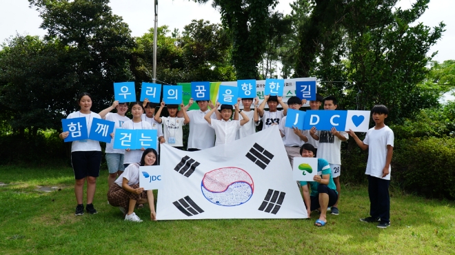 제주국제자유도시개발센터(JDC)가 개최한 'JDC 꿈꾸는 장학생 드림캠프' 참가 학생들이 직접 만든 태극기와 함께 기념사진을 찍고 있다. 사진=JDC 