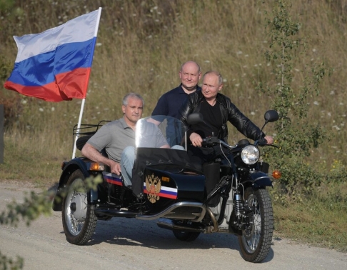 10일(현지 시간) 러시아가 실효 지배하고 있는 우크라이나 남부 크림공화국에서 블라디미르 푸틴 러시아 대통령이 러시아 국기를 휘날리며 우랄 사이드카를 몰고 있다.