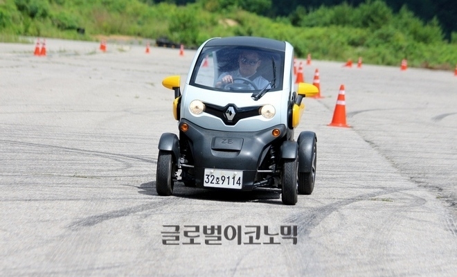 행사에 참석한 한 기자가 소형 전기차 트위지를 타고 슬라럼 체험을 하고 있다.