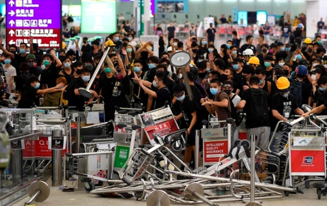 홍콩공항의 시위대 점거가 14일에도 이어지고 전날 중국계 기자가 폭행당하는 사태가 발생 중국정부를 자극하면서 긴장감이 고조되고 있다.