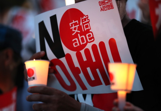 10일 오후 서울 종로구 옛 주한 일본대사관 앞에서 열린 '아베규탄 4차 촛불문화제'에서 참가자들이 촛불을 들고 있다./연합뉴스 