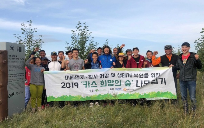 푸른아시아 관계자, 몽골 대학생, 현지 주민으로 구성된 환경봉사단 20여 명이 몽골 ‘카스 희망의 숲’ 일대에서 나무심기 봉사활동을 마치고 기념촬영을 하고 있다. 사진=오비맥주