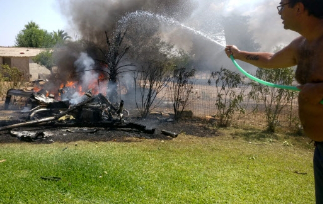 스페인 마요르카섬의 한 주민이 25일(현지시간) 헬리콥터와 경비행기의 공중 충돌로 적어도 7명이 숨진 가운데 지상에 떨어진 잔해에다 물을 뿌려 불을 끄려 하고 있다.