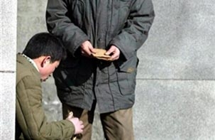 평양의 한 지하철 역 바깥에서 두 남자가 달러를 암거래 하고 있다.사진=RFA/AFP