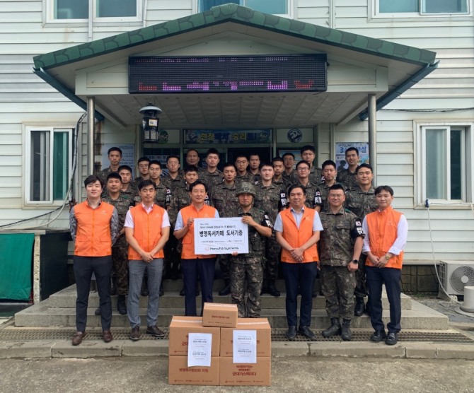 29일 한화시스템 직원들이 육군 28사단을 방문해 장병들과 함께 기념사진을 찍고 있다. 사진=한화시스템