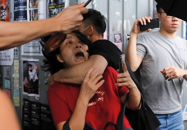 14일 홍콩 카우룽베이 아모이 프라자에서 반중 시위에 참여한 남성(검은옷)이 친중 집회 참여 여성을 공격하고 있다. 이곳에서 친중 반중 시위대간 몸싸움이 벌어졌다. 사진= 뉴시스