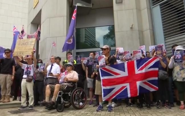 홍콩에서 15일 영국기나 영국 식민지 시대의 홍콩 깃발을 손에 들고  영국 총영사관 앞에 집결한 민주 성향의 시민들.