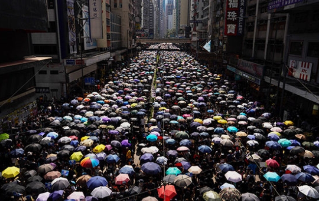 15일 모든 가게가 문을 닫은 홍콩 번화가에서 우산을 들고 시위를 벌이고 있는 수십만 명의 시민들.
