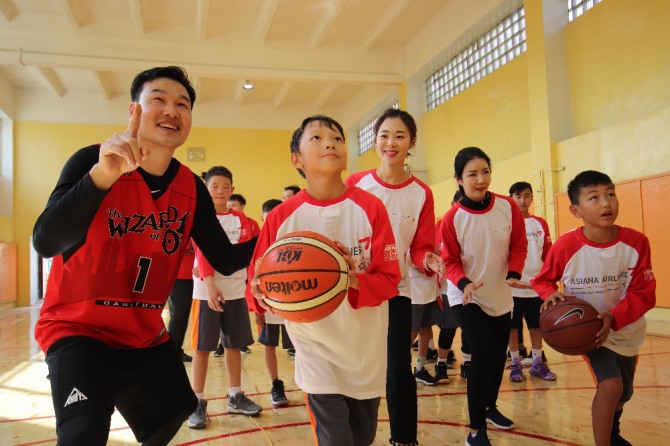 행사에 참석한 아시아나항공 직원들이 83번초등학교 학생들과 함께 체육관에서 농구 연습을 하고 있다. 사진=아시아나항공