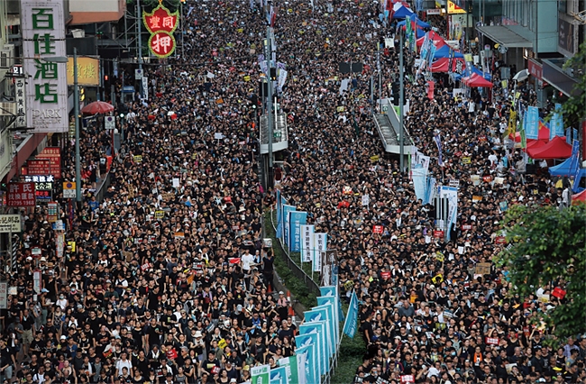 홍콩의 반정부시위가 3개월을 넘기고 있는 가운데 전문가들은 이 시위가 21세기 후반 세계현실을 묻는 국제문제로 비화될 것이라는 전망을 내놓고 있다. 사진은 지난 6월의 200만 명이 참가한 시위의 모습.
