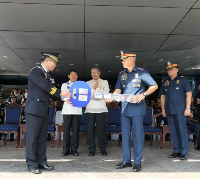 지난달 26일 필리핀 마닐라 경찰청(PNP) 본청에서 열린 KR모터스의 '아퀼라125' 경찰순찰용 오토바이 인도식에 참석한 민갑룡 경찰청장이 알바얄데 PNP경찰청장에게 모형 차량열쇠를 전달하고 있다. 사진=KR모터스