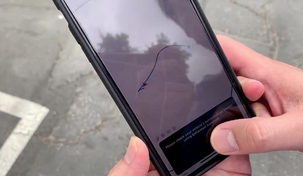 테슬라 모델3를 소유한 한 자동차운전자가 미국 캘리포니아주 포모나에서 스마트폰을 이용해 자동차를 호출하고 있는 모습. 사진=로이터/뉴스1
