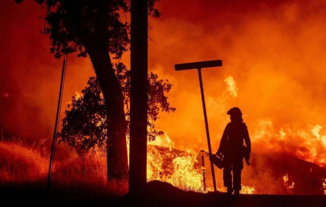 미국 캘리포니아 산불화재 진화작업에 나선 소방대원이 망연자실한 모습으로 치솟는 불길을 지켜보고 있다.