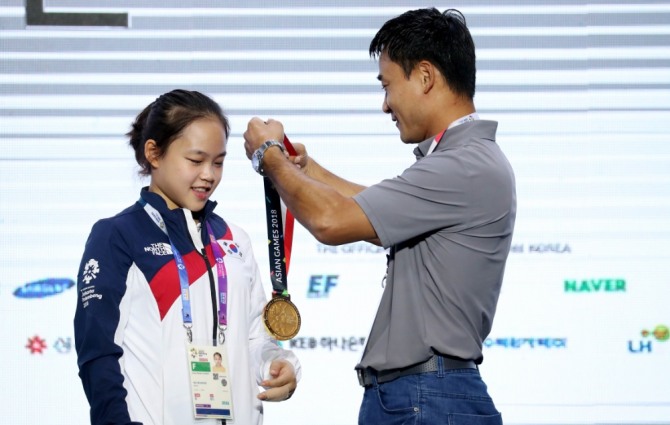 지난 2018 자카르타-팔렘방 아시안게임 체조 메달리스트 기자회견이 열린 25일(현지시각) 오전 인도네시아 자카르타 코리아하우스에서 여홍철 교수가 딸인 체조 금메달리스트 여서정에게 금메달을 걸어주고 있다.사진=뉴시스 