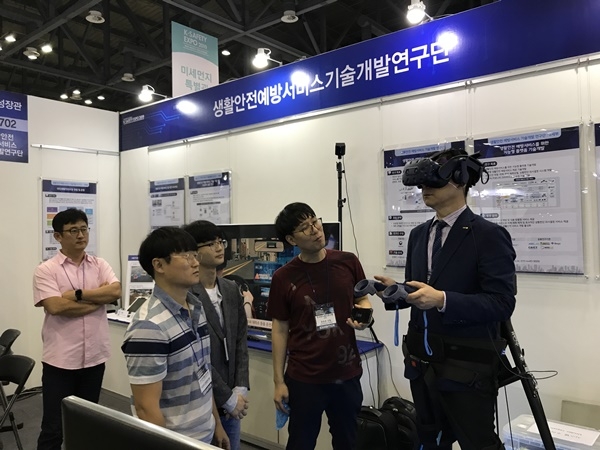 권승준  ETRI 선임연구원이 VR 헤드셋을 쓰고 화재 시 소화기 사용 방법을 체험할 수 있도록 설명하는 모습. 사진=ETRI