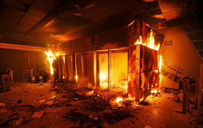 칠레의 수도 산티아고에서 일어난 폭동으로 양탈과 방화로 인해 불타고 있는 점포.