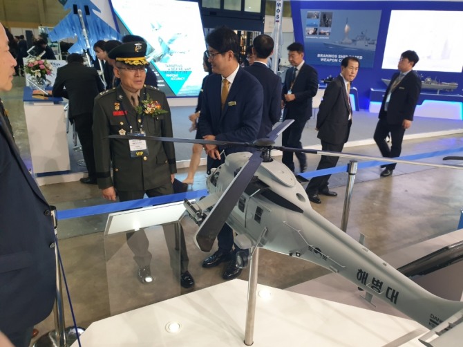 해병대부사령관인 서헌원 소장이 25일 MADEX 2019에서 배기홍 KAI 상무로부터 상륙공격헬기에 대한 설명을 듣고 있다. 사진=KAI