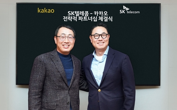 SK텔레콤 유영상 사업부장(왼쪽)과 카카오 여민수 공동대표(오른쪽)가 3000억 규모의 주식을 교환하고, 미래 ICT 분야에서 사업 협력을 추진하는 전략적 파트너십을 체결하고 기념촬영을 하고 있다. 사진=SKT