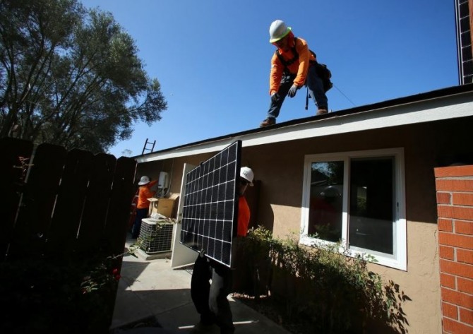 캘리포니아주 샌디에이고의 스크립스 랜치에서 작업자들이 태양광 패널을 지붕에 설치하고 있다. 사진=로이터