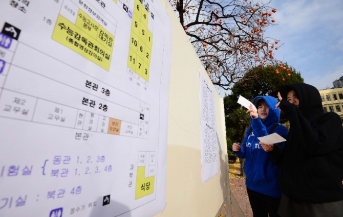 지난해 11월 대학수학능력시험 예비소집 당시 서울 종로구 풍문여고에서 수험생들이 수험번호와 고사장을 확인하고 있다.사진=뉴시스