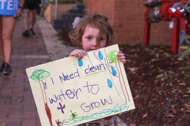 10월 26일(현지시간) 호주 뉴사우스웨일스주 의회 앞에서 열린 센트럴코스트 와이용 광산 개발 반대 집회에서 한 어린이가 '나는 성장하기 위해 깨끗한 물이 필요해요'라는 글이 쓰인 그림을 들고 있다. 사진=그린레프트위클리  