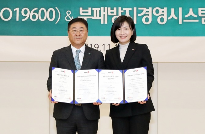 강태희 하나금융지주 준법감시인(사진 왼쪽)이 황은주 한국경영인증원장으로부터 준법경영시스템(ISO19600)과 부패방지경영시스템(ISO37001) 국제 표준 인증서를 동시에 받은 뒤 기념촬영을 하고 있다.