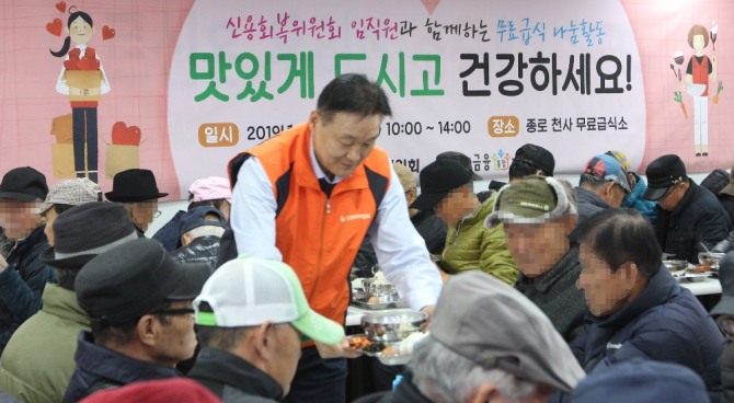 이계문 신용회복위원장이 신복위 신입직원들과 함께 서울 종로 천사 무료급식소의 봉사활동에 참여해 어르신에게 설렁탕을 나눠주고 있다. 사진=신용회복위원회 